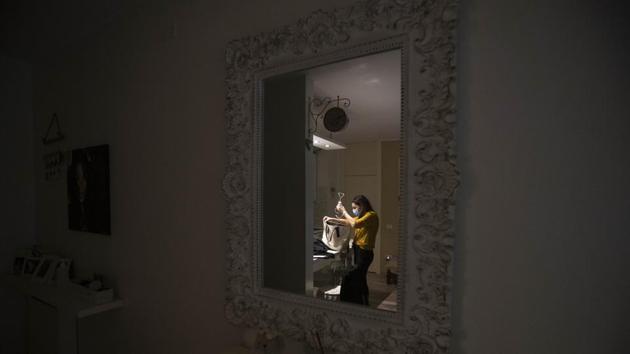 Cristina Settembrese is reflected in a mirror in her apartment in Basiglio. Once off-duty, the nurses call each other to ask how their patients are doing. “We feel a little like we’re their family,” Settembrese said. “They are patients who enter into your soul.” (Luca Bruno / AP) Cristina Settembrese is reflected in a mirror in her apartment in Basiglio. Once off-duty, the nurses call each other to ask how their patients are doing. “We feel a little like we’re their family,” Settembrese said. “They are patients who enter into your soul.” (Luca Bruno / AP)