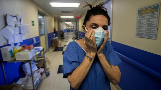 Cristina Settembrese fixes two face masks on top of each other during her work shift in the COVID-19 ward. The 54-year-old has been a nurse since she was 18. Two months ago, the infectious disease ward where she works started treating only COVID-19 patients. (Luca Bruno / AP) Cristina Settembrese fixes two face masks on top of each other during her work shift in the COVID-19 ward. The 54-year-old has been a nurse since she was 18. Two months ago, the infectious disease ward where she works started treating only COVID-19 patients. (Luca Bruno / AP)