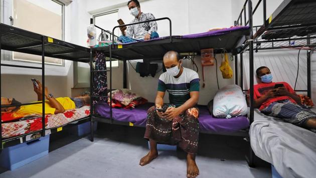 People wearing face masks are seen in a quarantine room in Westlite Toh Guan dormitory, in Singapore. More than 200,000 workers from Bangladesh, India and other Asian countries live in tightly packed dormitories. Clusters of infections have expanded rapidly in the dorms after they were overlooked in the government’s earlier health measures. (Ministry of Manpower Singapore via REUTERS) People wearing face masks are seen in a quarantine room in Westlite Toh Guan dormitory, in Singapore. More than 200,000 workers from Bangladesh, India and other Asian countries live in tightly packed dormitories. Clusters of infections have expanded rapidly in the dorms after they were overlooked in the government’s earlier health measures. (Ministry of Manpower Singapore via REUTERS)