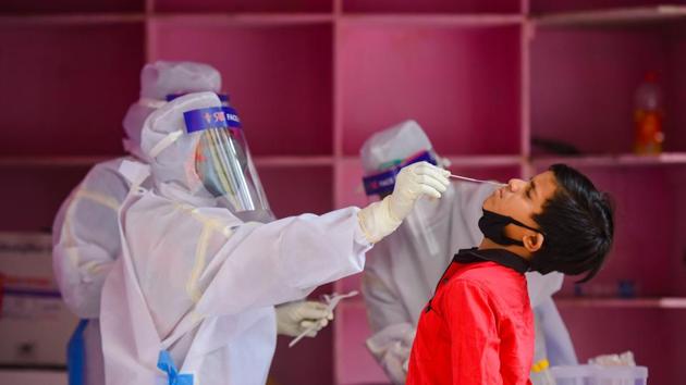 A medical worker takes a swab from a child during a COVID-19 testing drive(Amal KS/HT PHOTO)