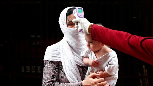 A health worker scans a resident with an infrared thermometer to check her temperature as a precautionary measure against the spread of the coronavirus disease (COVID-19) at a residential area in New Delhi, India.(REUTERS) A health worker scans a resident with an infrared thermometer to check her temperature as a precautionary measure against the spread of the coronavirus disease (COVID-19) at a residential area in New Delhi, India.(REUTERS)