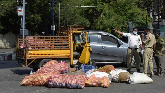 Police officials stand next to a transport vehicle which overturned while carrying a heavy load of vegetable bags in Hyderabad, on April 21. (Noah Seelam / AFP) Police officials stand next to a transport vehicle which overturned while carrying a heavy load of vegetable bags in Hyderabad, on April 21. (Noah Seelam / AFP)