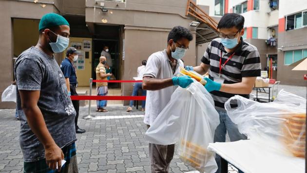 Food distribution takes place at Westlite Toh Guan dormitory. The government expects cases to rise further as testing at the dorms continues, but hopes that the country’s partial lockdown until May 4, mandatory wearing of masks and strict social distancing will help curb the spread of the virus. (Ministry of Manpower Singapore via REUTERS) Food distribution takes place at Westlite Toh Guan dormitory. The government expects cases to rise further as testing at the dorms continues, but hopes that the country’s partial lockdown until May 4, mandatory wearing of masks and strict social distancing will help curb the spread of the virus. (Ministry of Manpower Singapore via REUTERS)