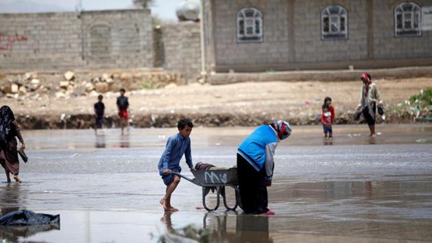 People carry their belongings washed by rain water after the heavy rain in Sanaa, Yemen April 17, 2020. (REUTERS) People carry their belongings washed by rain water after the heavy rain in Sanaa, Yemen April 17, 2020. (REUTERS)