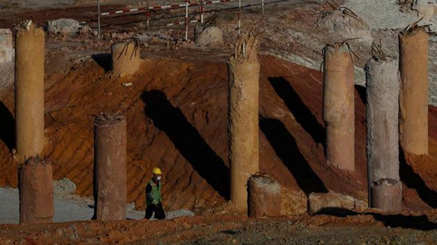 A migrant worker walks among foundation pilings at a construction site. Labour advocates earlier warned that confinement en mass in dormitories may put the workers at greater risk. There are concerns about the pace of testing, reportedly less than 3,000 a day, and workers living outside the 43 registered dormitories. (Edgar Su / REUTERS) A migrant worker walks among foundation pilings at a construction site. Labour advocates earlier warned that confinement en mass in dormitories may put the workers at greater risk. There are concerns about the pace of testing, reportedly less than 3,000 a day, and workers living outside the 43 registered dormitories. (Edgar Su / REUTERS)