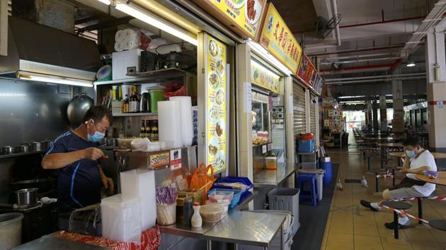 A vendor prepares food at a food court in an arcade in Singapore. Wong said transmission across dormitories could have occurred at work sites or at places where the workers congregate on their days off. The government has ordered construction workers who live outside the dorms to be quarantined at home until May 4. (Wei Leng Tay / Bloomberg) A vendor prepares food at a food court in an arcade in Singapore. Wong said transmission across dormitories could have occurred at work sites or at places where the workers congregate on their days off. The government has ordered construction workers who live outside the dorms to be quarantined at home until May 4. (Wei Leng Tay / Bloomberg)
