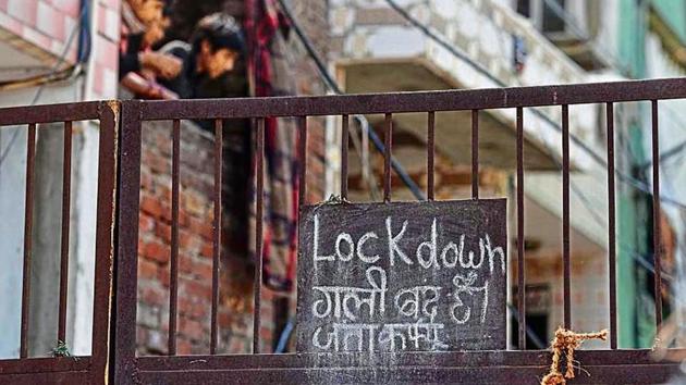 A public notice stating a lockdown hangs outside Jahangirpuri’s C Block, one of Delhi’s 87 containment zones, on Tuesday.(Sanchit Khanna/HT PHOTO)