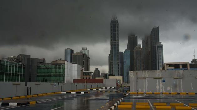 Storm clouds cover up the tops of buildings in the Dubai Marina as rain falls on a parking lot that stands empty over the coronavirus pandemic in Dubai, United Arab Emirates. (AP)