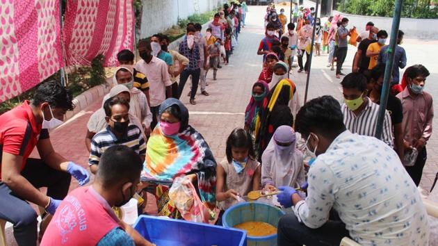 People line up to collect food at DLF Phase 4, Chakkarpur, in Gurugram,  on Tuesday, 21 April 2020. (Yogendra Kumar/HT Photo)