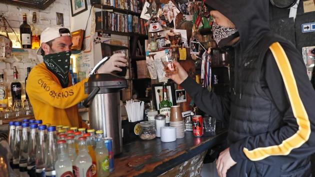 Derek Tigue (L), toasts a walk-in customer. “It’s been a harsh pill to swallow, not only for us but for all small businesses,” said Tigue, referring to the three businesses’ 90% staff and revenue loss. (Kathy Willens / AP) Derek Tigue (L), toasts a walk-in customer. “It’s been a harsh pill to swallow, not only for us but for all small businesses,” said Tigue, referring to the three businesses’ 90% staff and revenue loss. (Kathy Willens / AP)