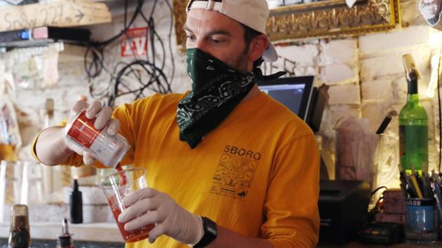 Derek Tigue whips up a bloody mary behind the bar. Using the suppliers from their restaurants, the FMN General Store, sells staples breakfast and supper as well as some specialty items along with cat litter and pet food. They also carry high-demand items like toilet paper, paper towels, and hand sanitizer. (Kathy Willens / AP) Derek Tigue whips up a bloody mary behind the bar. Using the suppliers from their restaurants, the FMN General Store, sells staples breakfast and supper as well as some specialty items along with cat litter and pet food. They also carry high-demand items like toilet paper, paper towels, and hand sanitizer. (Kathy Willens / AP)
