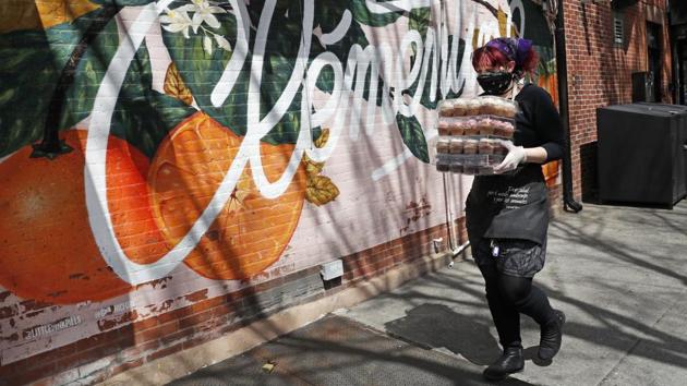 Head cake decorator Shelley Segroves watches her step as she carries freshly-iced cupcakes from the kitchen at Clementine Bakery in New York City. Across the East River in Brooklyn, the bakery and cafe added fresh produce, fresh local bread, and protective gloves to their normal vegan fare for customers who don't want to risk going to crowded grocery stores. (Kathy Willens / AP) Head cake decorator Shelley Segroves watches her step as she carries freshly-iced cupcakes from the kitchen at Clementine Bakery in New York City. Across the East River in Brooklyn, the bakery and cafe added fresh produce, fresh local bread, and protective gloves to their normal vegan fare for customers who don't want to risk going to crowded grocery stores. (Kathy Willens / AP)