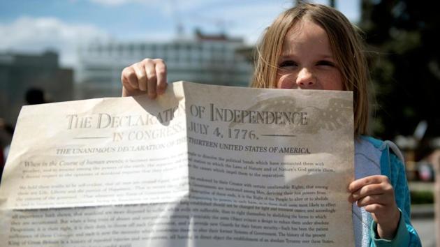 A young girl holds a copy of The Declatation of Independence as demonstrators gather to protest coronavirus stay-at-home orders during a "ReOpen Colorado" rally in Denver,  on April 19. (Jason Connolly / AFP) 