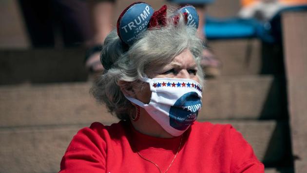 A demonstrator wearing a Trump 2020 face mask gathers with others to protest coronavirus stay-at-home orders in Denver, on April 19.  (Jason Connolly / AFP) 