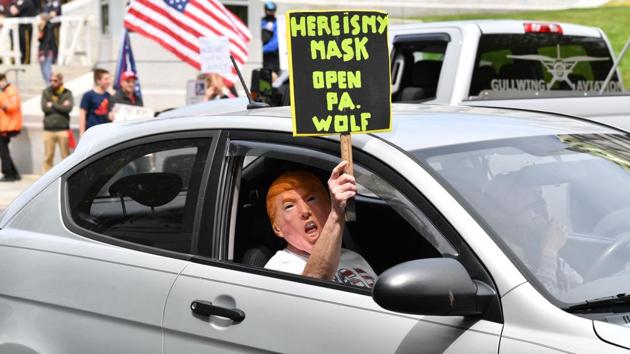 A man holds a sign as people take part in a “reopen” Pennsylvania demonstration on April 20, in Harrisburg. The US president has however expressed sympathy for the protesters in his daily coronavirus briefings, saying he understands their frustration. (Nicholas Kamm  / AFP) 