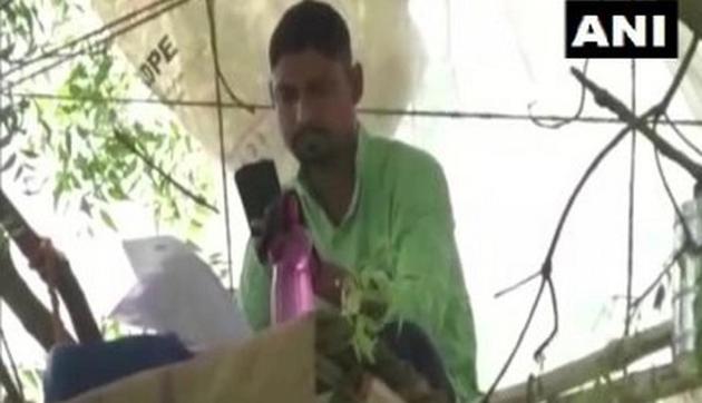 Subrato Pati uses his smartphone to take online classes from his workspace on the tree.(ANI)