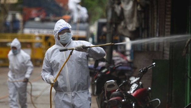 Municipal workers in protective gear disinfecting a Delhi street on Thursday. (Sanchit Khanna/HT PHOTO) Municipal workers in protective gear disinfecting a Delhi street on Thursday. (Sanchit Khanna/HT PHOTO)