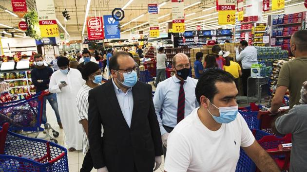 Majid Al Futtaim CEO Alain Bejjani, center left, and store manager Arnaud Bouf, center, walk through heavy shopping traffic during the coronavirus pandemic in the world's busiest Carrefour supermarket, at the Mall of the Emirates in Dubai, United Arab Emirates.(AP)