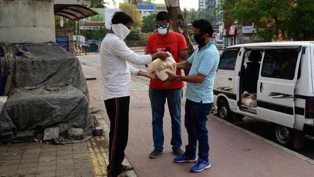 Vaibhav Wagh (R) distributing food in Warje on Thursday. (Sanket Wankhade/HT PHOTO) Vaibhav Wagh (R) distributing food in Warje on Thursday. (Sanket Wankhade/HT PHOTO)