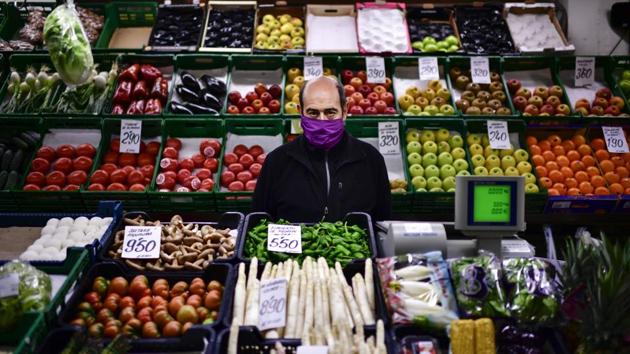 Ignacio Delgado poses for a photograph at his fruit market stall. (Alvaro Barrientos / AP)