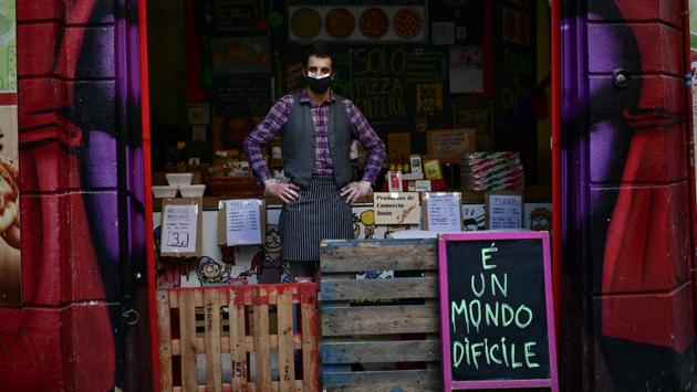 Miguel Angel Pena in his food store. While hundreds of thousands in Spain have lost their jobs during the lockdown, these few workers are making sure the basic needs and services function at the risk of also falling ill. (Alvaro Barrientos / AP)