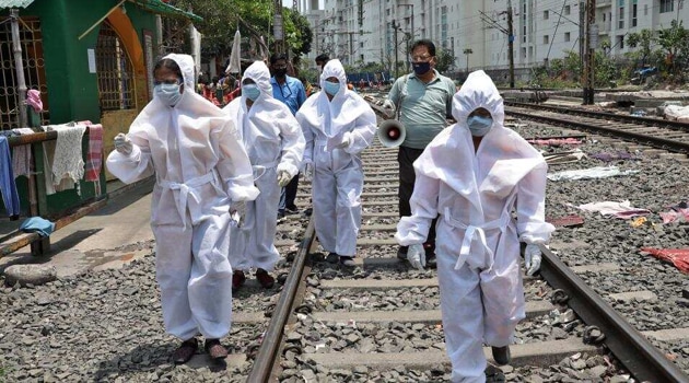 Health workers wearing protective gear walk on a railway track as they arrive in a slum area for a door-to-door verification of people to find out if they have developed any of the coronavirus disease (Covid-19) symptoms, in Kolkata, on April 24, 2020. (Reuters) Health workers wearing protective gear walk on a railway track as they arrive in a slum area for a door-to-door verification of people to find out if they have developed any of the coronavirus disease (Covid-19) symptoms, in Kolkata, on April 24, 2020. (Reuters)