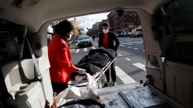 Nicole Warring (front) and Lily Sage Weinrieb remove a deceased person from a funeral service vehicle, in Manhattan. The refrigerated trailers outside of the hospitals don’t have enough shelving and bodies are sometimes stacked on top of each other and on the floor. Some trailers don’t even have lights. (Andrew Kelly / REUTERS) Nicole Warring (front) and Lily Sage Weinrieb remove a deceased person from a funeral service vehicle, in Manhattan. The refrigerated trailers outside of the hospitals don’t have enough shelving and bodies are sometimes stacked on top of each other and on the floor. Some trailers don’t even have lights. (Andrew Kelly / REUTERS)