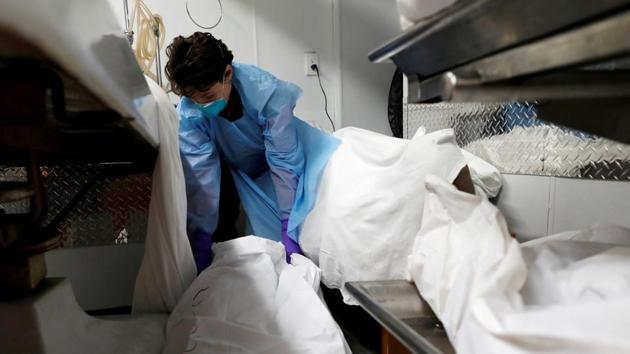 Weinrieb positions a deceased person in the basement prep area, where bodies are stored and prepared for funeral services, during the outbreak. Most COVID-19 victims die alone, and when they die, their families are told to quarantine. The women try to find ways for them to say goodbye. (Andrew Kelly / REUTERS) Weinrieb positions a deceased person in the basement prep area, where bodies are stored and prepared for funeral services, during the outbreak. Most COVID-19 victims die alone, and when they die, their families are told to quarantine. The women try to find ways for them to say goodbye. (Andrew Kelly / REUTERS)