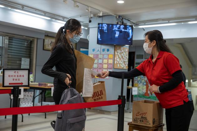 A student shows her identity document to check before attending to take the Diploma of Secondary Education (DSE) exams, following the coronavirus disease outbreak in Hong Kong. (Reuters Photo) A student shows her identity document to check before attending to take the Diploma of Secondary Education (DSE) exams, following the coronavirus disease outbreak in Hong Kong. (Reuters Photo)