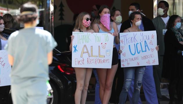People hold signs thanking healthcare workers outside UCLA hospital in Los Angeles, California as the global outbreak of coronavirus disease continues.(Reuters Photo) People hold signs thanking healthcare workers outside UCLA hospital in Los Angeles, California as the global outbreak of coronavirus disease continues.(Reuters Photo)