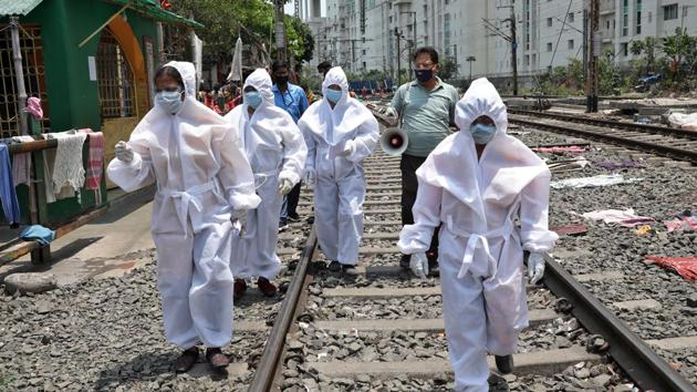 Health workers wearing protective gear walk on a railway track as they arrive in a slum area for a door-to-door verification of people to find out if they have developed any of the coronavirus disease (COVID-19) symptoms, in Kolkata, on April 24, 2020. (REUTERS) Health workers wearing protective gear walk on a railway track as they arrive in a slum area for a door-to-door verification of people to find out if they have developed any of the coronavirus disease (COVID-19) symptoms, in Kolkata, on April 24, 2020. (REUTERS)