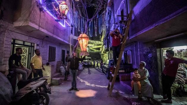Egyptian youth decorate their residential street in preparation Ramzan in Cairo’s Hadayek el-Maadi district, on April 21. (Khaled Desouki / AFP) Egyptian youth decorate their residential street in preparation Ramzan in Cairo’s Hadayek el-Maadi district, on April 21. (Khaled Desouki / AFP)