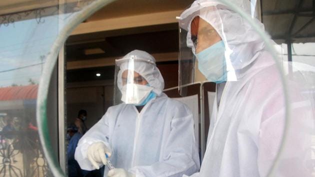 Health officials (L) uses a swab to collect a sample from a person for Covid-19 test. (ANI photo) Health officials (L) uses a swab to collect a sample from a person for Covid-19 test. (ANI photo)