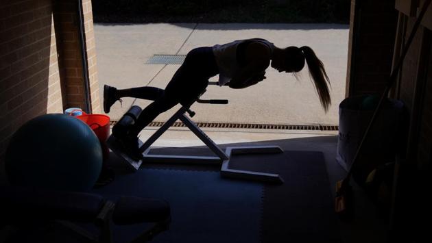 With the COVID-19 restrictions in place, Barber’s training base is in her garage, with cars moved out and gym equipment moved in. Her apartment living room has become her yoga and massage studio and the local park her training ground. (Loren Elliott / REUTERS)