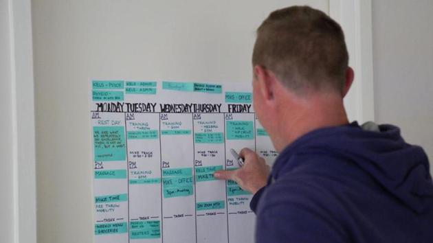 Mike Barber, husband and coach of javelin world champion Kelsey-Lee Barber, adds to her training schedule calendar inside the couple's home as they continue preparations for the postponed Tokyo Olympic Games. (Loren Elliott / REUTERS)