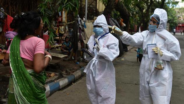 Municipal health department staff in Personal Protection Equipment (PPE) overalls screen people for body temparature, and take notes on ILI symptoms at Subodh Mullick Square in Kolkata, West Bengal. (Samir Jana/HT Photo) Municipal health department staff in Personal Protection Equipment (PPE) overalls screen people for body temparature, and take notes on ILI symptoms at Subodh Mullick Square in Kolkata, West Bengal. (Samir Jana/HT Photo)