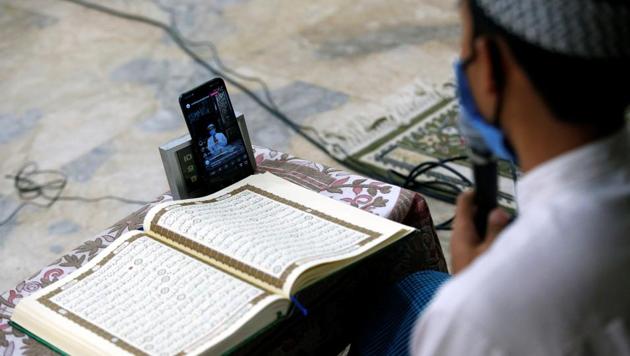Bambang Suprianto, an Imam wearing a protective mask, reads the Koran while streamed through social media inside Sunda Kelapa mosque, closed as the government imposed large-scale restrictions to prevent the spread of coronavirus disease (COVID-19), a moment before iftar during the holy fasting month of Ramadan, in Jakarta, Indonesia, April 25, 2020. REUTERS/Willy Kurniawan (REUTERS) Bambang Suprianto, an Imam wearing a protective mask, reads the Koran while streamed through social media inside Sunda Kelapa mosque, closed as the government imposed large-scale restrictions to prevent the spread of coronavirus disease (COVID-19), a moment before iftar during the holy fasting month of Ramadan, in Jakarta, Indonesia, April 25, 2020. REUTERS/Willy Kurniawan (REUTERS)