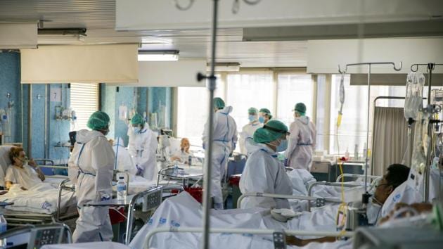 Healthcare workers assist a COVID-19 patients at one of the intensive care units (ICU) of the Ramon y Cajal hospital in Madrid, Spain.(AP)