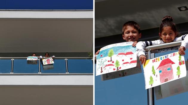 Vasilis Bekiaris, 10, and Aggeliki Bekiaris, 7, hold pictures that they drew, as they stand on the balcony of their home in Thessaloniki, Greece. The writings in Greek in the drawings read: “I want spring back” and “We stay home” -- which is the national slogan of Greece against the outbreak, reported Reuters. Vasilis drew spring and Aggeliki drew a house. (Murad Sezer / REUTERS) Vasilis Bekiaris, 10, and Aggeliki Bekiaris, 7, hold pictures that they drew, as they stand on the balcony of their home in Thessaloniki, Greece. The writings in Greek in the drawings read: “I want spring back” and “We stay home” -- which is the national slogan of Greece against the outbreak, reported Reuters. Vasilis drew spring and Aggeliki drew a house. (Murad Sezer / REUTERS)