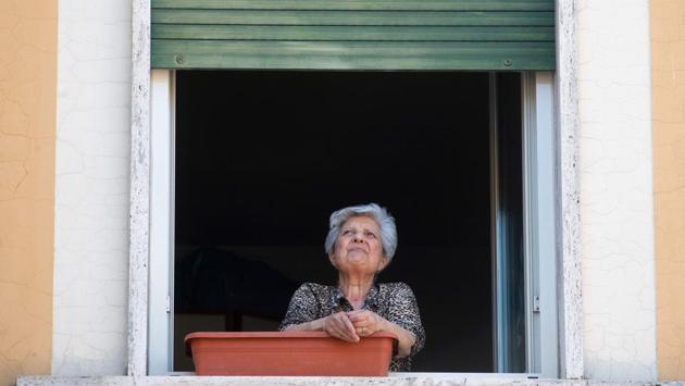 A resident in the Garbatella district of Rome takes part in the 'Liberation Day' flashmob from her window . Populist far right leader Matteo Salvini voiced his displeasure with Saturday’s singalong. He urged people to focus on the coronavirus outbreak, rather than singing ‘Bella Ciao.’ (Tiziana Fabi / AFP)