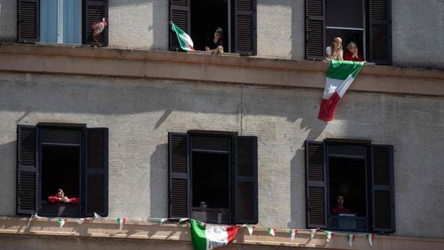 Residents in the Garbatella district of Rome wave the Italian flag as they take part in a 'Liberation Day' flashmob with people singing 'Bella Ciao' from their windows. Italy was liberated from Benito Mussolini’s Fascist regime by the US and its European allies weeks before the Nazis’ surrender in Berlin. (Tiziana Fabi / AFP)