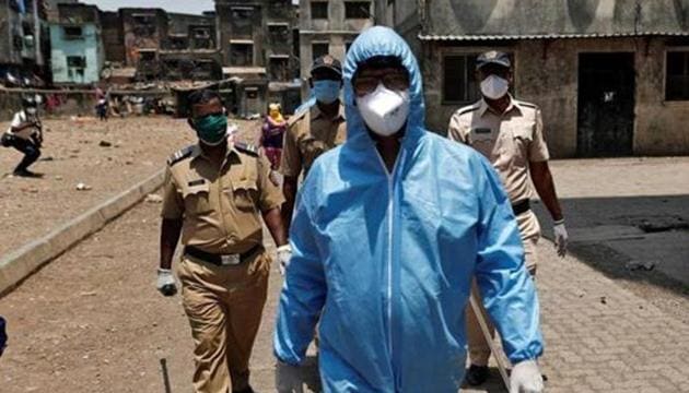 Health workers wearing hazmat suits and masks are accompanied by police officers as they conduct an inspection in a residential area, during a nationwide lockdown in India to slow the spread of COVID-19, in Dharavi, one of Asia's largest slums, during the coronavirus disease outbreak, in Mumbai, April 11, 2020. (REUTERS) Health workers wearing hazmat suits and masks are accompanied by police officers as they conduct an inspection in a residential area, during a nationwide lockdown in India to slow the spread of COVID-19, in Dharavi, one of Asia's largest slums, during the coronavirus disease outbreak, in Mumbai, April 11, 2020. (REUTERS)
