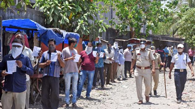 People stand in a queue holding penalty memo issued by police who broke lockdown rule during the nationwide lockdown to curb the spread of Coronavirus, in Surat on April 26, 2020. (ANI) People stand in a queue holding penalty memo issued by police who broke lockdown rule during the nationwide lockdown to curb the spread of Coronavirus, in Surat on April 26, 2020. (ANI)