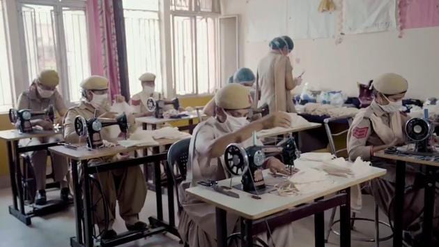 Policewomen making masks on sewing machines.(Twitter/@DelhiPolice)