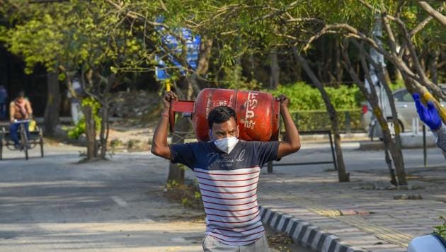 A man carries LPG cylinder on his shoulder during the lockdown in New Delhi on Monday.(PTI)