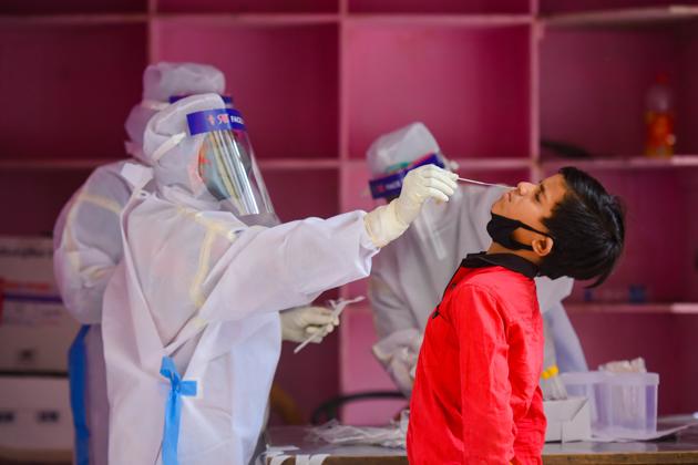 A medical worker takes a swab from a child during a Covid-19 testing drive, New Delhi, April 20, 2020 (Amal KS/HT PHOTO) A medical worker takes a swab from a child during a Covid-19 testing drive, New Delhi, April 20, 2020 (Amal KS/HT PHOTO)