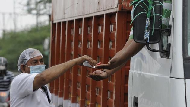 A health worker dispenses sanitiser to a truck driver at Noida gate, in Noida, Sunday, April 26, 2020. (Sunil Ghosh / HT Photo) A health worker dispenses sanitiser to a truck driver at Noida gate, in Noida, Sunday, April 26, 2020. (Sunil Ghosh / HT Photo)