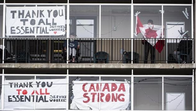 A resident untangles a Canadian flag in order to tape it back up to a window on a balcony at Laurier Manor, a long-term care facility experiencing an outbreak of Covid-19, Sunday, April 26, 2020, in Ottawa, Ontario. (AP) A resident untangles a Canadian flag in order to tape it back up to a window on a balcony at Laurier Manor, a long-term care facility experiencing an outbreak of Covid-19, Sunday, April 26, 2020, in Ottawa, Ontario. (AP)