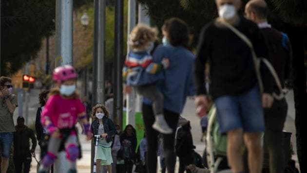 Families with their children walk along a boulevard in Barcelona, Spain, Sunday, April 26, 2020 as the lockdown to combat the spread of coronavirus continues. (AP) Families with their children walk along a boulevard in Barcelona, Spain, Sunday, April 26, 2020 as the lockdown to combat the spread of coronavirus continues. (AP)