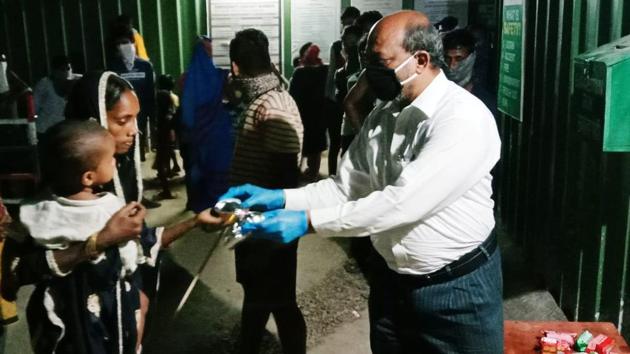 Anwar Shaikh, principal of the college distributes food to migrants. (HT PHOTO) Anwar Shaikh, principal of the college distributes food to migrants. (HT PHOTO)